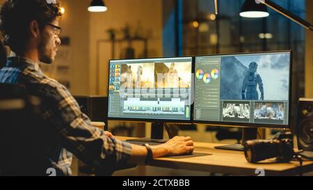 Bureau créatif de fin de soirée : vidéaste professionnel travaille sur ordinateur de bureau, faisant des films montage, en utilisant le logiciel d'édition vidéo. Vidéo moderne Banque D'Images