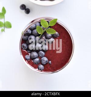 Close up of frappé aux bleuets en verre sur fond noir en lumière. Boissons naturelles saines. Haut de la vue, télévision lay Banque D'Images