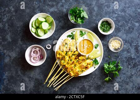 Satay de poulet avec sauce aux arachides. Brochettes de poulet grillées servies avec sauce à la sauce aux cacacahuètes. Repas savoureux pour le dîner ou les hors-d'œuvre de fête. Pierre bleue dos Banque D'Images