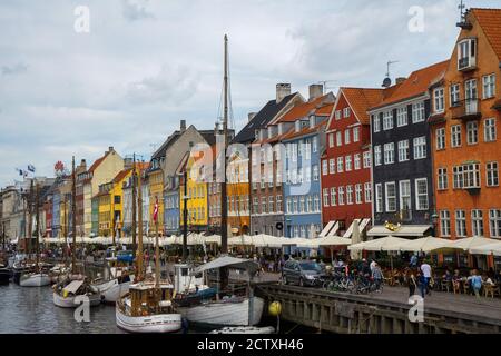 Nyhavn est un front de mer et un canal à Copenhague, au Danemark. Façades colorées de maisons et vieux navires le long du canal. Bateaux en bois amarrés dans le canal.