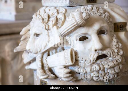 Ancien masque de théâtre, en marbre, situé à la base d'une colonne romaine à Rome - Italie Banque D'Images