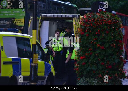 Les policiers des West Midlands gardent une ambulance car un suspect est traité par des ambulanciers paramédicaux du West Midlands Ambulance Service, Birmingham, Colmore Row Banque D'Images