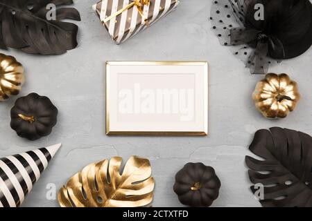 Arrière-plan moderne pour Halloween avec citrouilles dorées et noires, monstère, confetti étoiles et cadre doré. Maquette de carte d'invitation de fête d'Halloween. Pose à plat Banque D'Images
