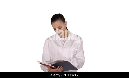 Jeune médecin femme lisant la documentation tout en marchant sur blanc Banque D'Images