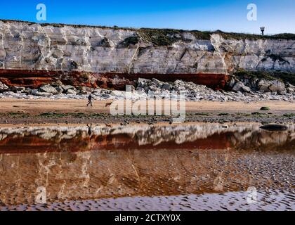 Falaises de Carstone rouge réfléchis et falaises de craie blanche à faible Tide Sur Hunstanton Beach Banque D'Images