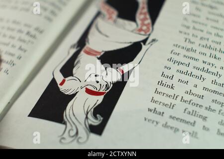 Page du livre avec dessin pour les enfants d'Alice tomber dans un trou Banque D'Images