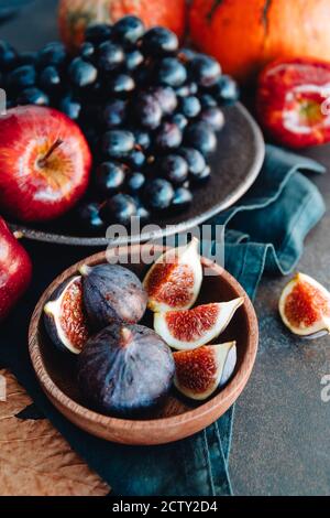 Nourriture d'automne, pommes rouges, figues, raisins et citrouille. Banque D'Images