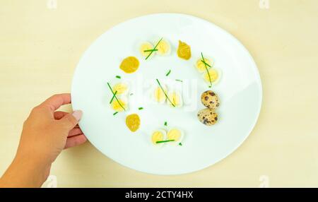 œufs de caille bouillis avec moutarde et ciboulette sur une assiette Banque D'Images