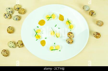 œufs de caille bouillis avec moutarde et ciboulette sur une assiette Banque D'Images