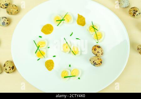 œufs de caille bouillis avec moutarde et ciboulette sur une assiette Banque D'Images