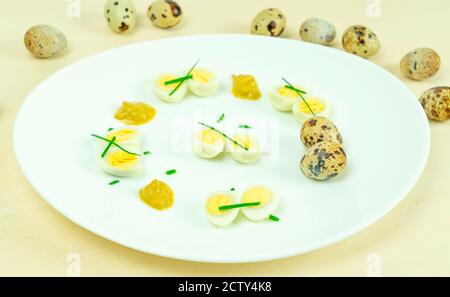 œufs de caille bouillis avec moutarde et ciboulette sur une assiette Banque D'Images