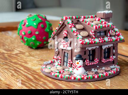 Maison en pain d'épice en argile. Miniature. Cadeau de Noël à faire soi-même. La maison en argile est décorée de bonbons rouges et verts, de bonbons, de biscuits. Banque D'Images