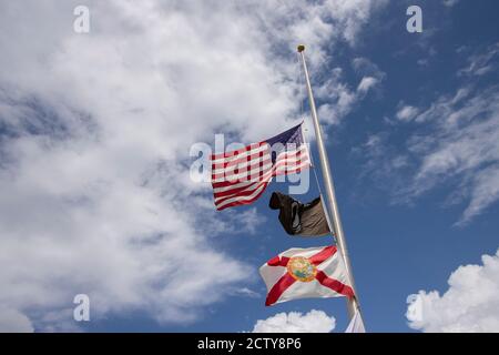 Drapeaux volant à mi-mât, y compris le drapeau IA POW Et le drapeau de l'État de Floride Banque D'Images