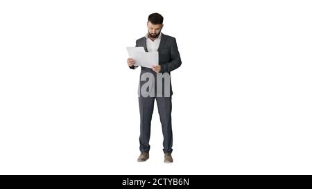 Homme d'affaires debout et lisant des journaux sérieusement sur fond blanc Banque D'Images