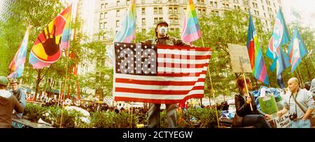 Occupez le manifestant de Wall Street tenant le drapeau américain, Zuccotti Park, Lower Manhattan, Manhattan, New York City, New York State, États-Unis Banque D'Images