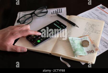 Objets utilisés lors du paiement de factures ou du transport de finances domestiques. Argent, calculatrice, crayon et factures sur un ordinateur portable. Effectuer des calculs. Banque D'Images