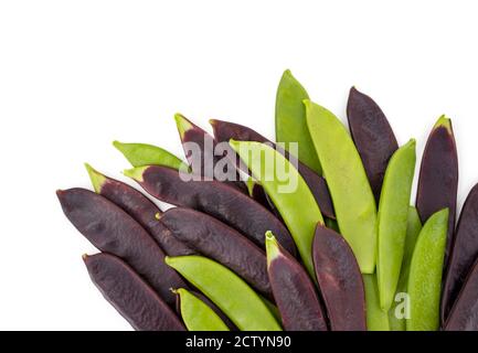 Assortiment de pois à sucre vert et de pois à neige violets. Vue de dessus des gousses de pois alignées en bas. Légumes riches en protéines. Légumes frais. Banque D'Images