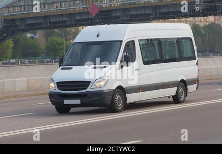 Minibus blanc va sur la ville street Banque D'Images