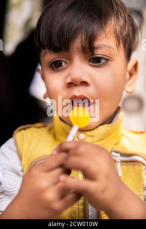 Couper le petit garçon mangeant des bonbons de Lollipop et s'amuser en plein air à l'heure de la journée.00. Banque D'Images