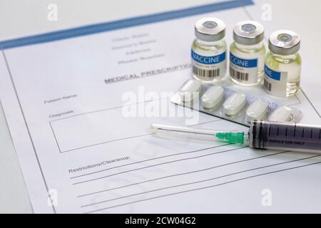 Seringue d'injection avec flacons de vaccin et comprimés avec le patient liste de médicaments sur fond blanc Banque D'Images