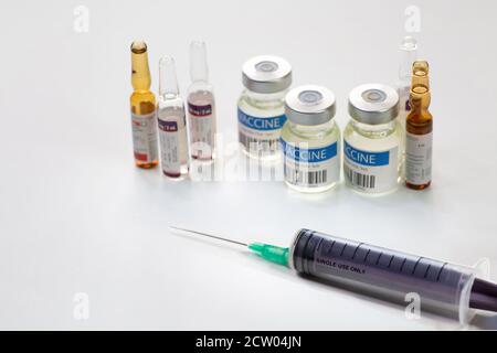 Aiguille de seringue hypodermique avec flacons de vaccin et flacons d'injection arrière-plan blanc Banque D'Images