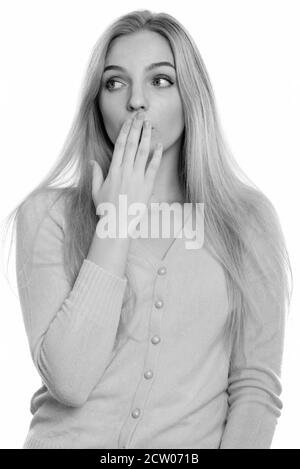 Studio shot of young Beautiful woman couvrant la bouche tout en regardant choqué Banque D'Images