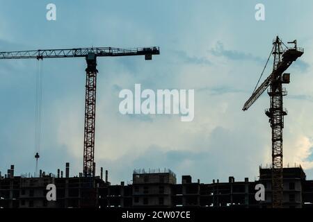 Grues à tour au-dessus du bâtiment en construction. Banque D'Images