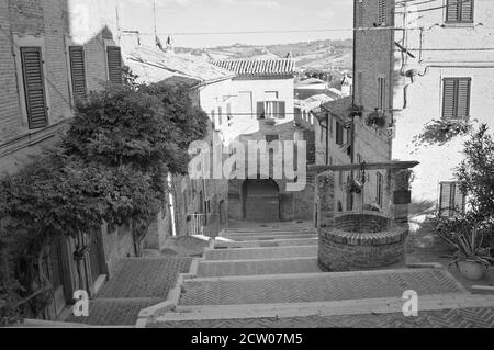 Un escalier dans un village médiéval italien avec un vieux puits en briques (Corinaldo, Marche, Italie, Europe) Banque D'Images