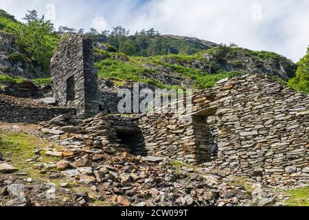 Les ruines de bâtiments à mi-chemin vers le bord de l'eau dans la vallée de Tilberthwaite, dans le district des lacs. Il s'agit peut-être de carrières. Banque D'Images