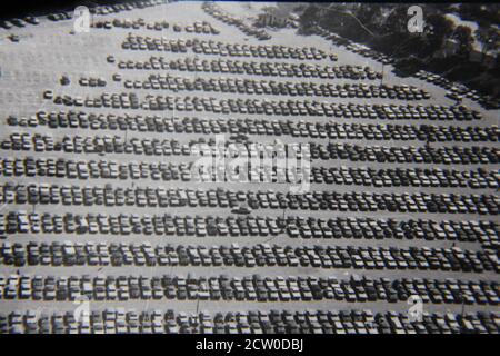 Belle photographie en noir et blanc vintage des années 1970 d'une vue aérienne d'un parking hug plein de voitures garées. Banque D'Images