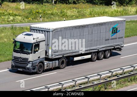 Camion Mercedes-Benz Actros éclairé avec remorque en bordure de trottoir sur autoroute. Banque D'Images