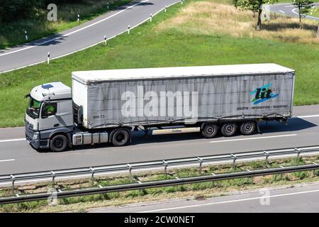 Camion Mercedes-Benz Actros éclairé avec remorque en bordure de trottoir sur autoroute. Banque D'Images