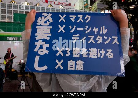 Un homme tient un panneau pour protester contre les mesures prises pour voter Covid-19 lors d'une manifestation dans un centre commercial ou d'un « festival de clusters » par des activistes anti-masques japonais sur la place Hachiko, Shibuya, Tokyo, Japon. Samedi 26 septembre 2020.. Les militants sont partisans du controversé YouTuber devenu politicien plein d’espoir, Hiratsuka Masayuki, qui s’est présenté sans succès au gouverneur de Tokyo lors des élections du 5 juillet 2020 sous le parti libéral de souveraineté populaire. La majorité des Japonais semblent se conformer au port de masque et à la distanciation sociale Banque D'Images