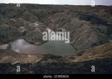 Photo historique des années 1970 : les séquelles de l'exploitation minière en bandes dans le comté de Monterey Fulton. Après que la terre a été dépouillée, la coupe se remplit souvent d'eau des sources souterraines et de la pluie. Depuis que toute la terre arable est enlevée, la terre dénudée reste stérile. Mai 1973 Banque D'Images