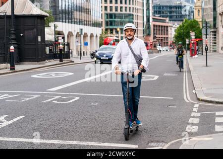 LONDRES, ANGLETERRE - 24 JUILLET 2020 : Indien d'âge moyen à Holborn et portant un casque d'accident lors d'un trajet pour le déjeuner Banque D'Images