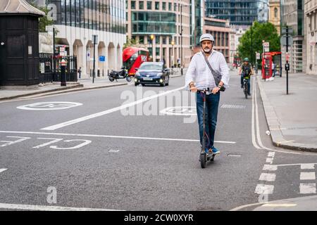 LONDRES, ANGLETERRE - 24 JUILLET 2020 : Indien d'âge moyen à Holborn et portant un casque d'accident lors d'un trajet pour le déjeuner Banque D'Images