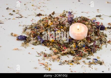 Pot-pourri de fleur sur table avec bougie allumée. Banque D'Images