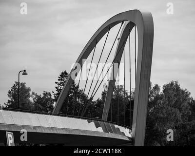 Helsinki / Finlande - 26 septembre 2020 : gros plan noir et blanc d'un pont de marche en arc avec rails en verre réfléchissants. Banque D'Images