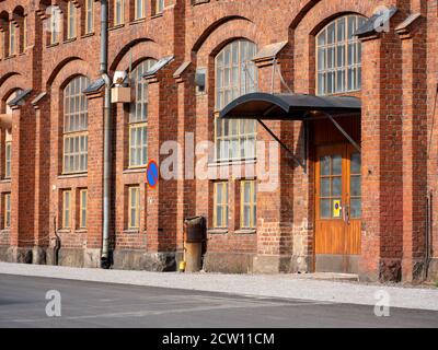 Helsinki / Finlande - 26 septembre 2020 : gros plan d'une entrée d'une ancienne usine industrielle en briques rouges avec des fenêtres voûtes d'époque. Banque D'Images