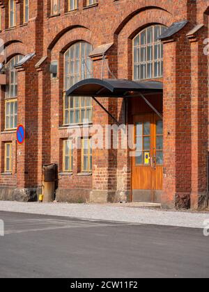 Helsinki / Finlande - 26 septembre 2020 : gros plan d'une entrée d'une ancienne usine industrielle en briques rouges avec des fenêtres voûtes d'époque. Banque D'Images