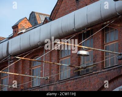 Helsinki / Finlande - 26 septembre 2020 : gros plan du mur d'une lampe accrochée à un ancien bâtiment industriel en brique rouge. Banque D'Images