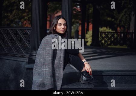 Belle jeune femme brune marche à Moscou. Portrait de mode en plein air d'une femme à la mode qui se pose dans la rue. Banque D'Images