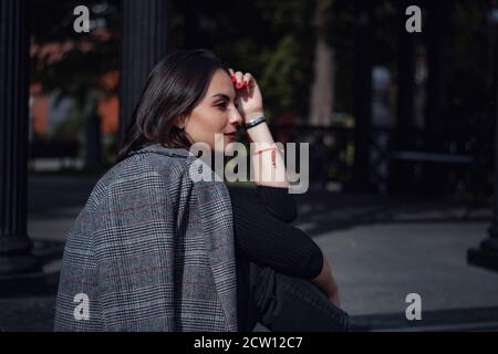 Belle jeune femme brune marche à Moscou. Portrait de mode en plein air d'une femme à la mode qui se pose dans la rue. Banque D'Images