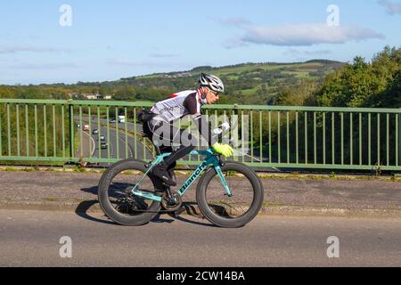 Cycliste de race bleue Bianchi Oltre sur la route de campagne traversant le pont autoroutier dans la campagne du Lancashire, Royaume-Uni Banque D'Images