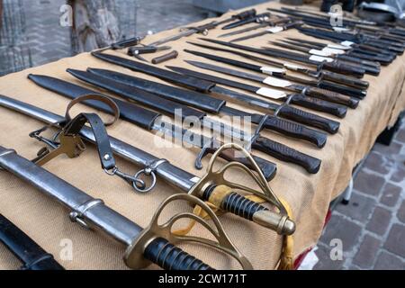 Toutes sortes d'épées avec des scabbards de différentes tailles affichées sur une table à vendre sur un marché antique à Tongeren, Belgique Banque D'Images