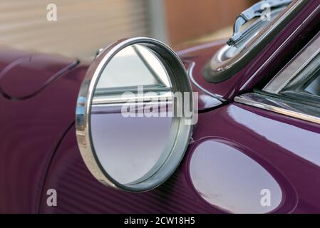 Rétroviseur arrière côté conducteur pour les passes à grande vitesse sur l'autoroute pour cette voiture violette. Banque D'Images