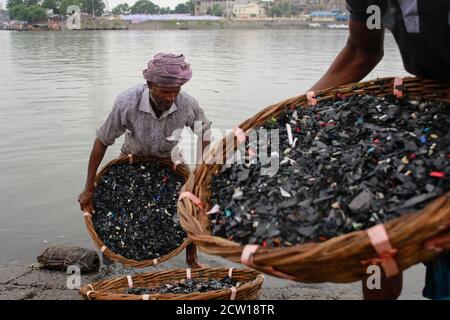 Dhaka, Bangladesh. 26 septembre 2020. Un homme bangladais lave les morceaux de matières plastiques usées dans la rivière Burigonga, Dhaka (Bangladesh), le 26 septembre 2020. Il y a environ 12-13 ans, le fleuve Buriganga était une voie d'eau populaire pour la communication et le transport de marchandises lorsqu'il coulait à travers Rasulpur à Kamrangirchar. Cependant, le Burigang ne peut plus être appelé une rivière car il a tellement rétréci qu'il est maintenant plus étroit qu'un canal. Les habitants de la région l'appellent maintenant une « rivière en plastique », même s'ils ont admis à la polluer avec des déchets en plastique. Dans la ville de Dhaka, plus de 14 millions de pièces de poly ba Banque D'Images