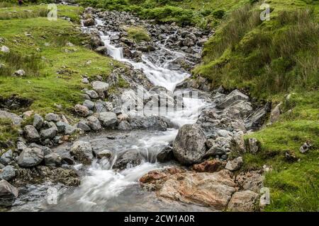 L'un des nombreux ruisseaux qui se dégringolent le long de la route Kirkstone Pass. Près de la route qui descend vers Brotherswater et Ullswater. Banque D'Images