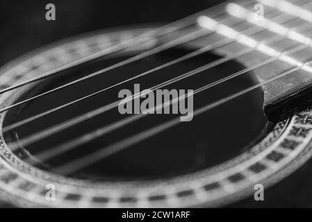 Détails d'une guitare acoustique, photos détaillées d'une guitare, cordes de guitare et son trou, abstrait, flou, macrophoto, noir et blanc Banque D'Images