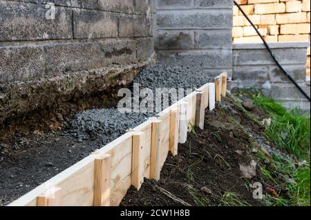 Cernment , tranchée de béton se remplissant pour soutenir le mur à la maison jardin Banque D'Images